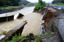 道路の一部が崩れ、水道管が脱落した